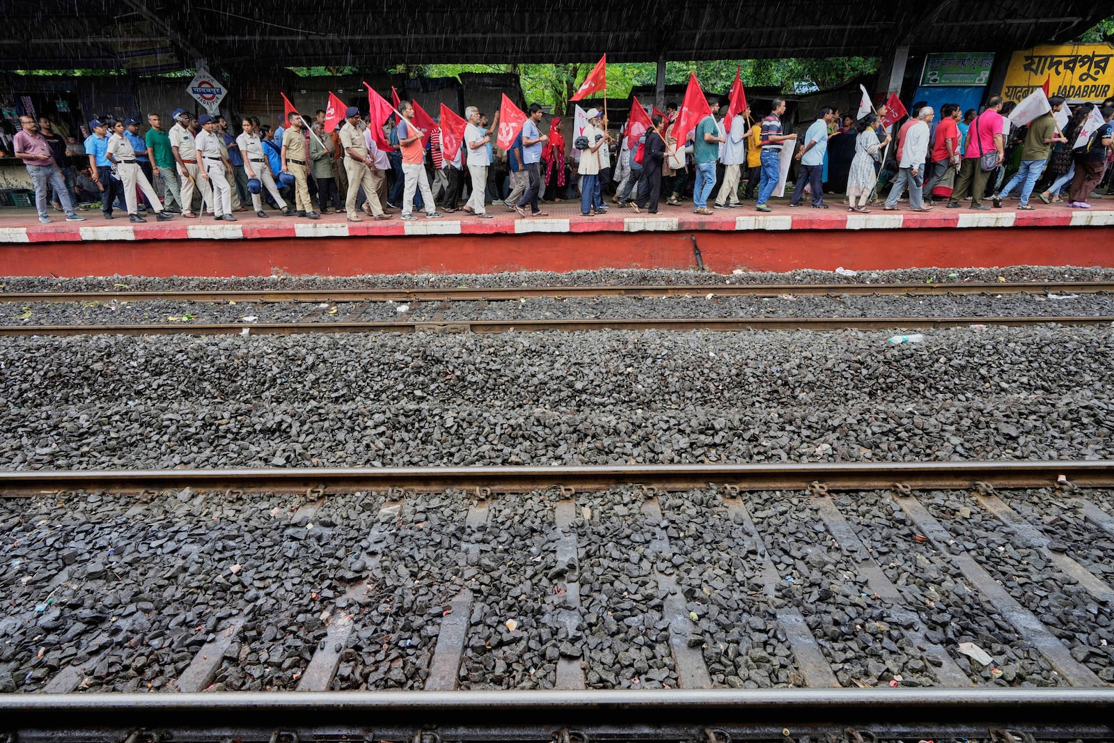 Supporters of Centre of India Trade Unions, CITU, walk in a rally on a railway station platform during a nation-wide strike to protest what they call the anti-labor and anti-poor policies of the federal government, in Kolkata, India, Wednesday, July 9, 2025. (AP Photo/Bikas Das)