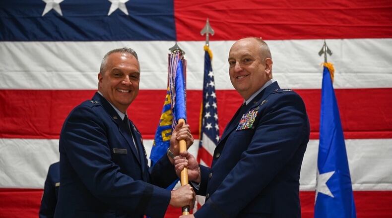 U.S. Air Force Brig. Gen. David Johnson passes the guidon to Col. Donald Braskett (right) during a change of command ceremony on Springfield-Beckley Air National Guard Base, Ohio, April 7, 2024. As the commander, he executes the remotely piloted aircraft MQ-9 Reaper mission. (U.S. Air National Guard photo by Airman 1st Class Josh Kaeser)