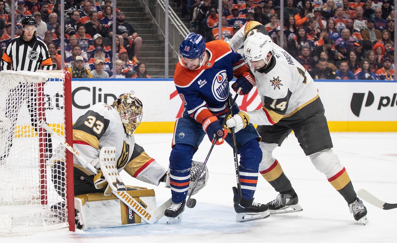 Vegas Golden Knights goalie Adin Hill (33) makes a save against Edmonton Oilers' Zach Hyman (18) as Golden Knights' Nicolas Hague (14) defends during the second period of Game 4 of a second-round NHL hockey playoff series in Edmonton, Alberta, Monday, May 12, 2025. (Jason Franson/The Canadian Press via AP)