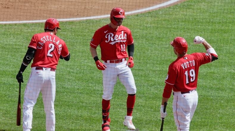 Tyler Naquin, of the Reds, returns to the dugout after leading off the first inning with a home run against the Pirates on Wednesday, April 7, 2021, at Great American Ball Park in Cincinnati. David Jablonski/Staff