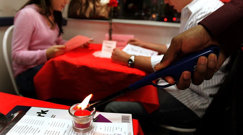 DES PLAINES, IL - FEBRUARY 14:  A candle is lit near the table of Leslie Adams and Rob Dockery during a Valentine's Day dinner at a White Castle restaurant February 14, 2006 in Des Plaines, Illinois. For Valentine's Day, numerous White Castle restaurants nationwide took dinner reservations offering candlelit dining with individual servers as well as hostess seating.  (Photo by Tim Boyle/Getty Images)