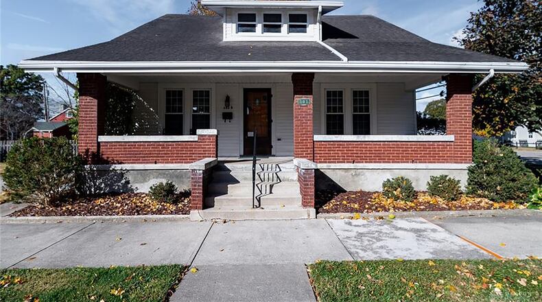 The front of the home has a full covered front porch with brick half wall and concrete floor. There is a concrete walkway leading to the front door. Contributed photo