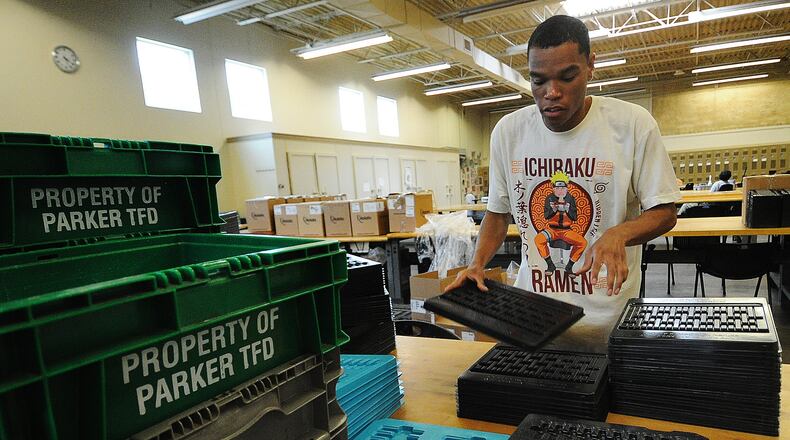 Damien, a worker at Better Living Home Health, stacks plastic trays that will be boxed and shipped away for a company. He is paid through the federal 14c program. MARSHALL GORBY\STAFF