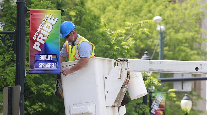 Springfield City employee Kevin Colvin hangs Springfield Pride banners along Limestone Street in 2016. BILL LACKEY/STAFF