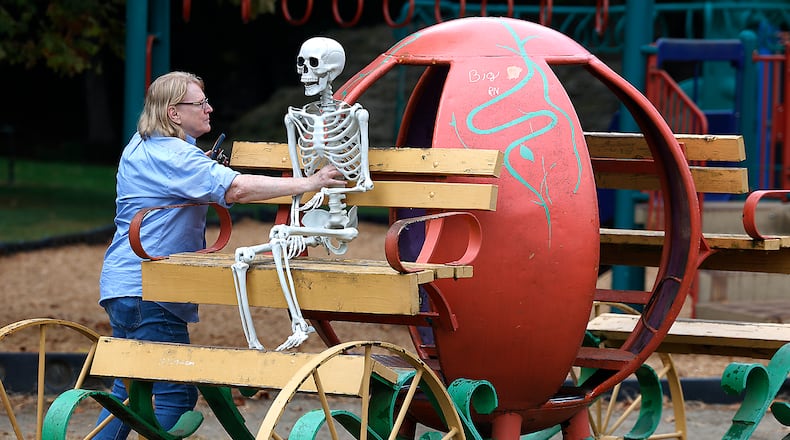 Sharon Thornton places her skeleton named "Hank" in the driver's seat of the pumpkin carriage at the Veterans Park playground Thursday, Sept. 28, 2023. Every year around Halloween, Sharon says she brings "Hank" out and takes pictures of him in random places around Springfield for the amusement of her family and friends. BILL LACKEY/STAFF