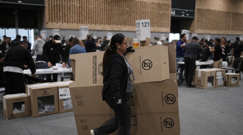An election official dismantles a voting booth after polls closed in legislative elections in Bogota, Colombia, Sunday, March 8, 2026. (AP Photo/Ivan Valencia)