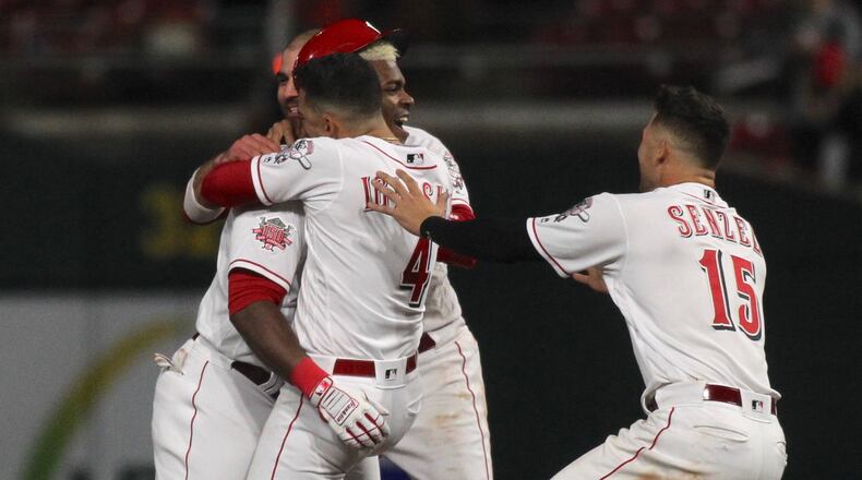 The Reds celebrate a walk-off, bases-loaded RBI single by Yasiel Puig in the 10th inning against the Cubs on Wednesday, May 15, 2019, at Great American Ball Park in Cincinnati.