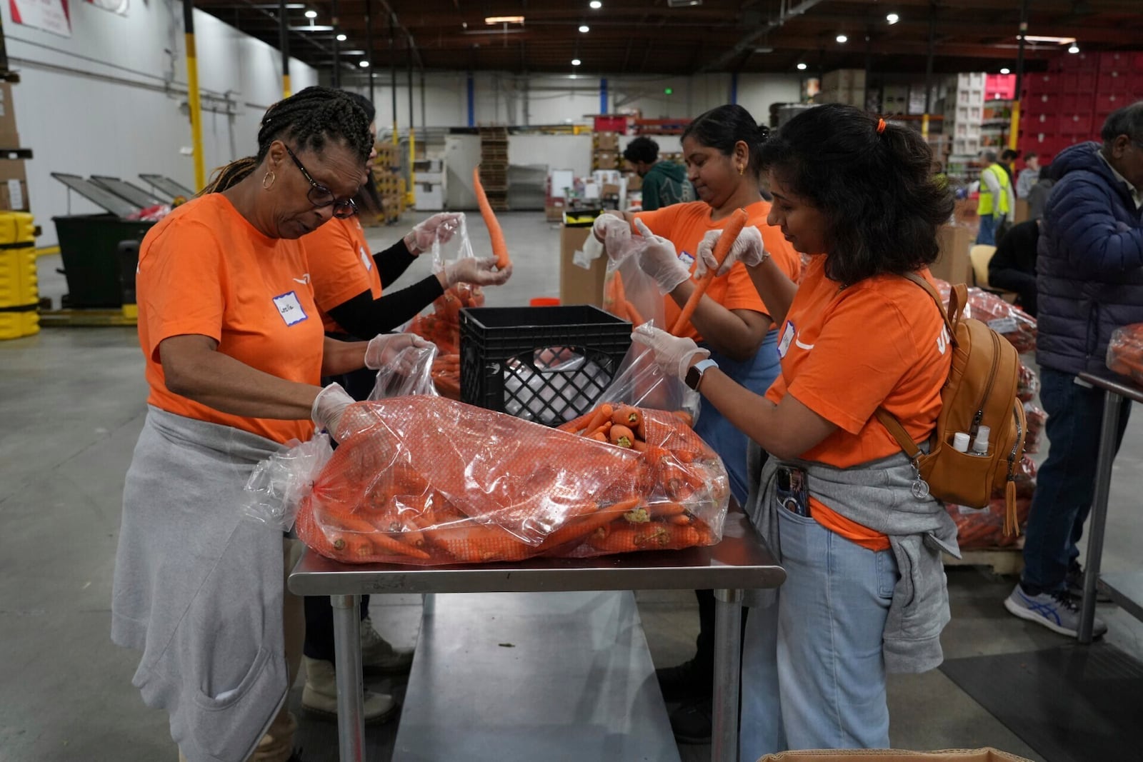 Volunteers pack produce at the Alameda County Community Food Bank in Alameda, Calif., on Friday, April 25, 2025. (AP Photo/Terry Chea)