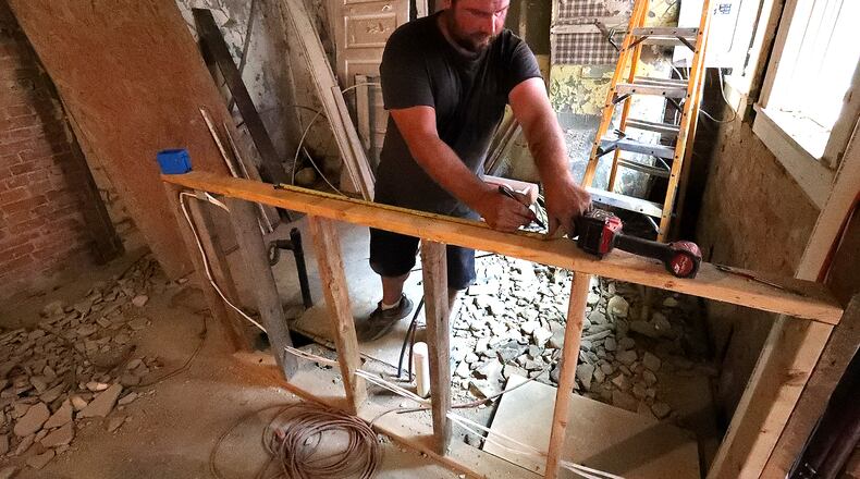 Matt Lewis, from Phoenix Builders works on one of the new apartments overlooking North Fountain Avenue in downtown Springfield Wednesday. BILL LACKEY/STAFF
