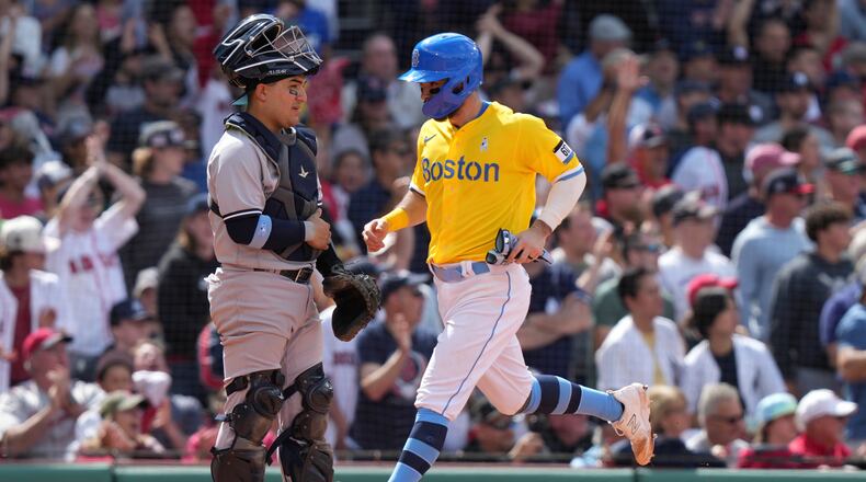 Boston Red Sox's Connor Wong, right, crosses home plate in front of New York Yankees' Jose Trevino, left, to score on a double by Red Sox's Alex Verdugo in the sixth inning of a baseball game, Sunday, June 18, 2023, in Boston. (AP Photo/Steven Senne)