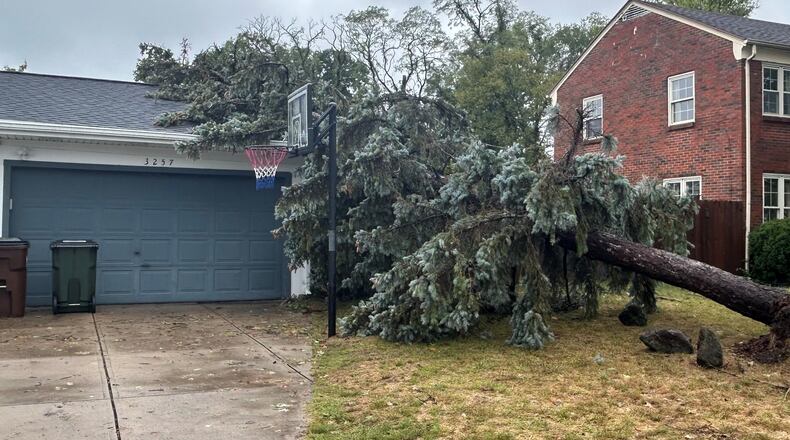A pine tree fell on a home on Far Hills Avenue in Kettering Friday night after strong winds blew through the region. Jeremy Kelley/Staff Photo