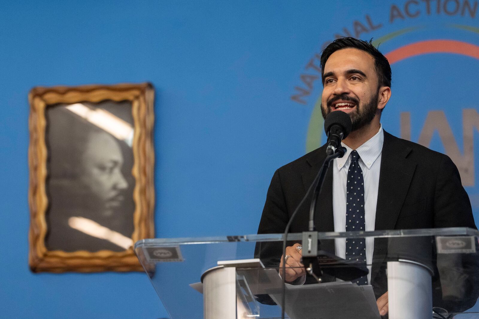 Democratic mayoral candidate Zohran Mamdani speaks next to a portrait of Martin Luther King Jr. during the National Action Network's Saturday action rally at House of Justice in Harlem, Saturday, June 28, 2025, in New York. (AP Photo/Yuki Iwamura)
