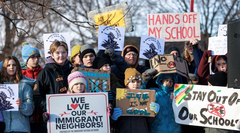 Minneapolis Public Schools families, educators and students hold signs during a news conference at Lake Hiawatha Park in Minneapolis, on Friday, Jan. 9, 2026, demanding Immigration and Customs Enforcement be kept out of schools and Minnesota following the killing of 37-year-old mother Renee Good by federal agents earlier on Wednesday. (Kerem Yücel/Minnesota Public Radio via AP)