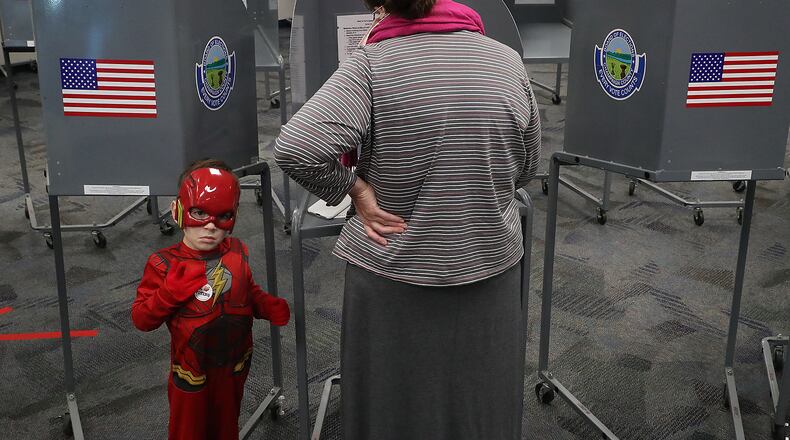 Emery Lowe, 5, aka The Flash, keeps an ever watchful eye on the election poll at the Champaign County Government Center Tuesday as his grandmother fills out her ballot. BILL LACKEY/STAFF