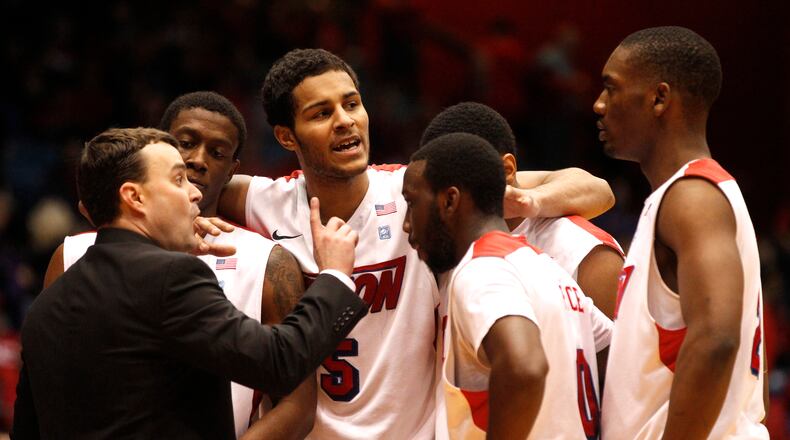 Dayton coach Archie Miller, left, huddles with his players late in the second half during a game against George Washington on Saturday, Feb. 1, 2014, at UD Arena. David Jablonski/Staff