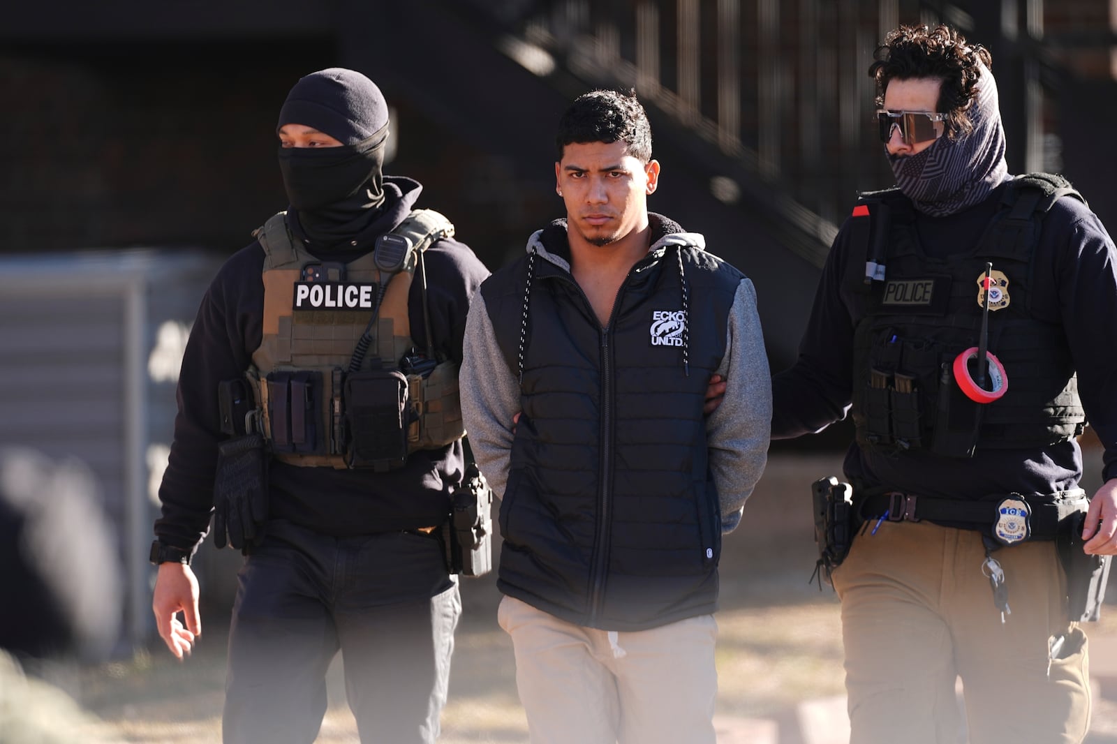 FILE - Law officials escort a suspect from an apartment to a waiting utility vehicle for transport during a raid Wednesday, Feb. 5, 2025, in east Denver. (AP Photo/David Zalubowski, File)