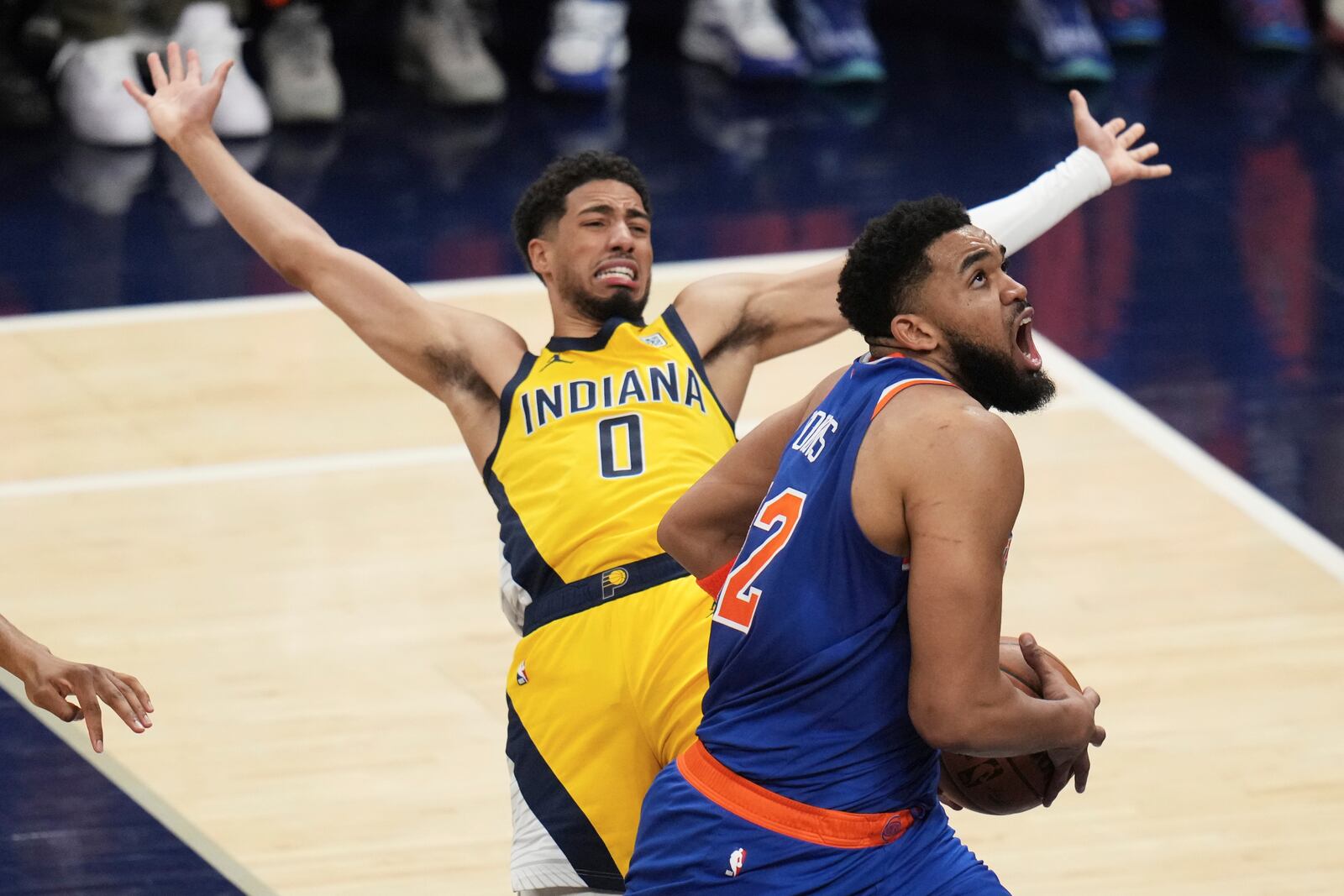 New York Knicks center Karl-Anthony Towns, right, drives to the basket against Indiana Pacers guard Tyrese Haliburton during the first half of Game 3 of the Eastern Conference finals of the NBA basketball playoffs Sunday, May 25, 2025, in Indianapolis. (AP Photo/Jeff Roberson)