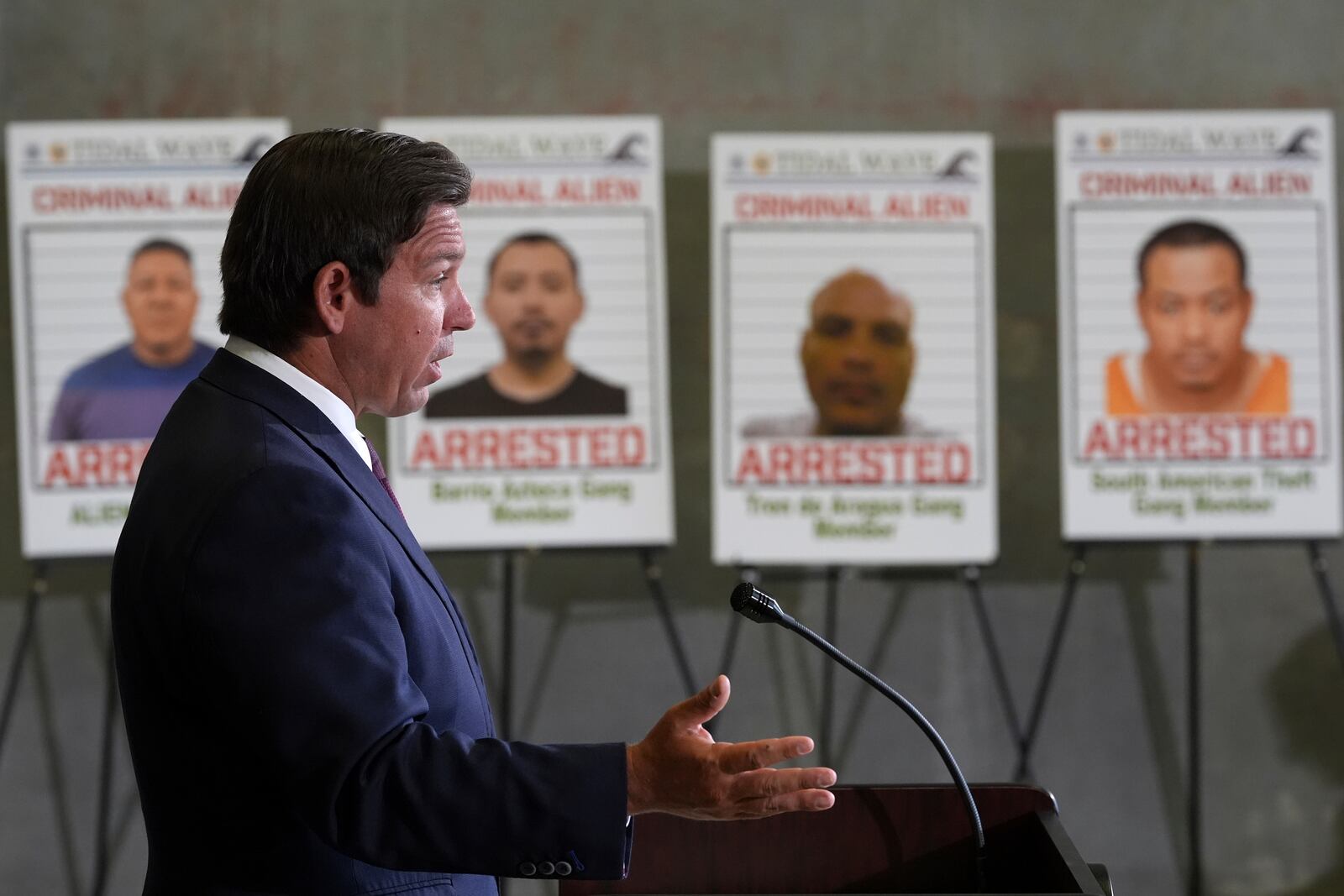 Posters of alleged criminals who officials said were arrested in a recent immigration enforcement operation are displayed as Gov. Ron DeSantis speaks during a press conference at the South Florida office of U.S. Immigration and Customs Enforcement and Enforcement and Removal Operations, Thursday, May 1, 2025, in Miramar, Fla. (AP Photo/Rebecca Blackwell)