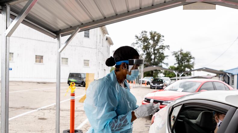 A worker collects a test specimen at Premier Health and CompuNet's OnMain testing site. The site will also do flu testing with physician orders. CONTRIBUTED