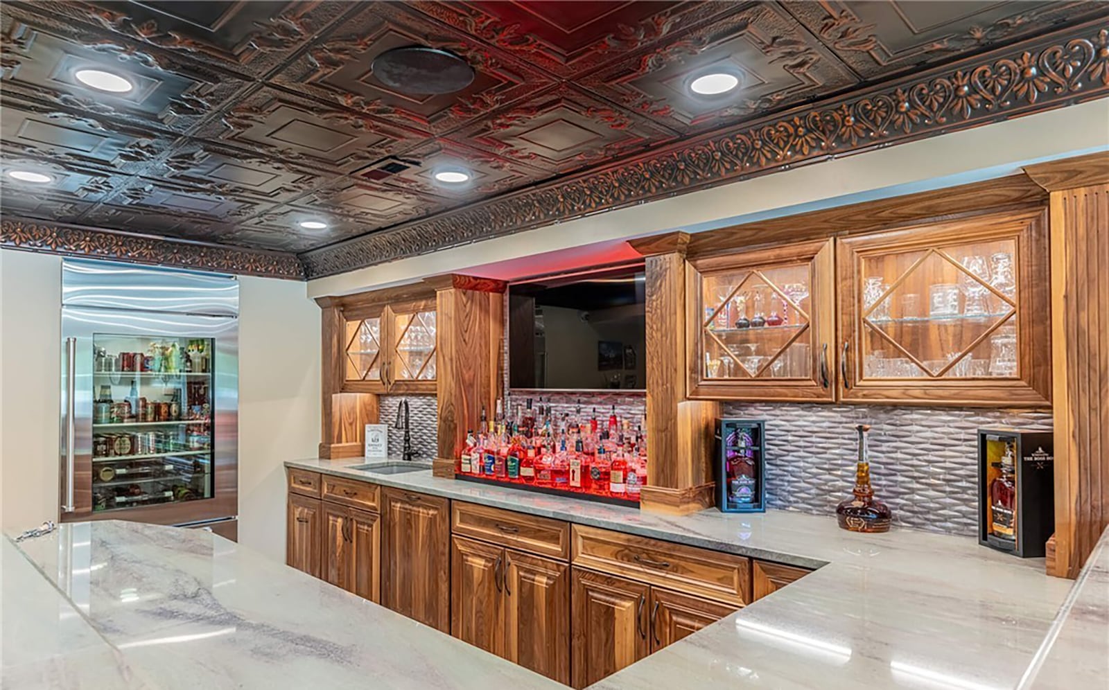 The finished basement features a bar with tin ceiling, custom backsplash and quartzite countertops.