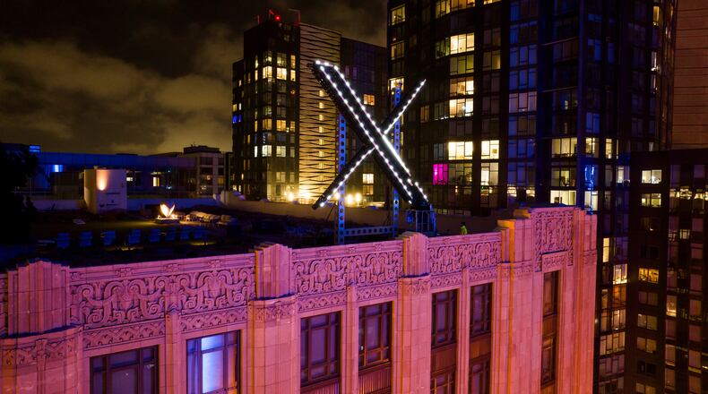 FILE - Workers install lighting on an "X" sign atop the company headquarters, formerly known as Twitter, in downtown San Francisco, July 28, 2023. (AP Photo/Noah Berger, File)