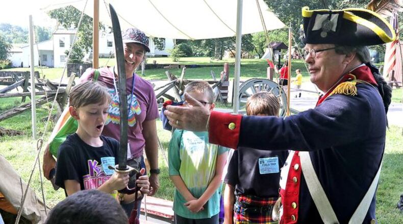 Dale Hawley explains the cannon to school children on Education Day. (BILL LACKEY)