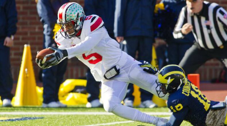 Ohio State quarterback Braxton Miller (5) dives in for a touchdown as Michigan defensive back Blake Countess (18) tries to stop him during the first quarter of an NCAA college football game in Ann Arbor, Mich., Saturday, Nov. 30, 2013. (AP Photo/Tony Ding)