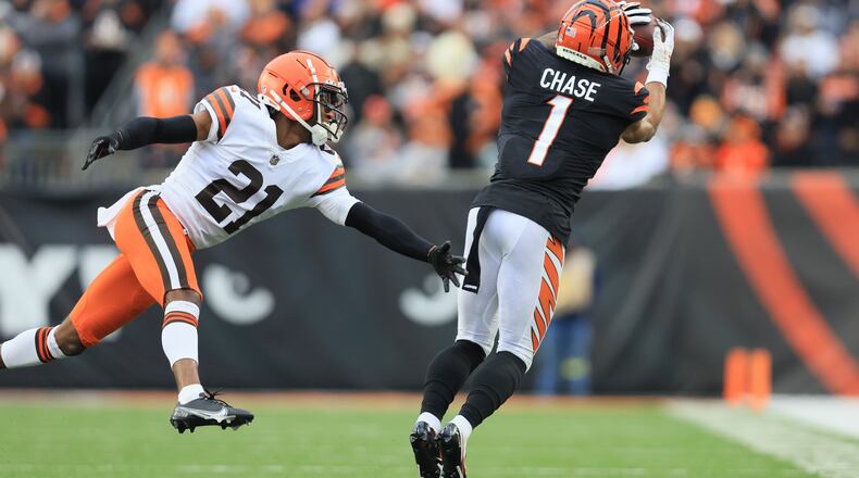 Cincinnati Bengals' Ja'Marr Chase (1) makes a catch against Cleveland Browns' Denzel Ward (21) during the second half of an NFL football game, Sunday, Dec. 11, 2022, in Cincinnati. (AP Photo/Aaron Doster)