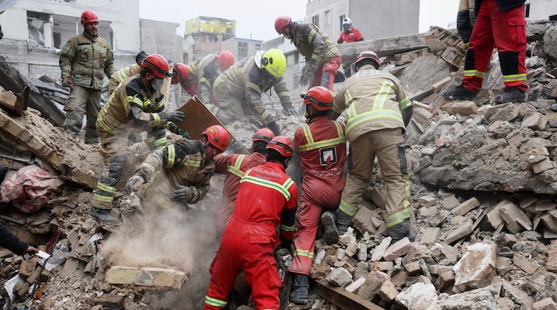 Rescue workers search for survivors in the rubble after a strike in southern Tehran, Iran, Friday, March 13, 2026. (AP Photo/Sajjad Safari)
