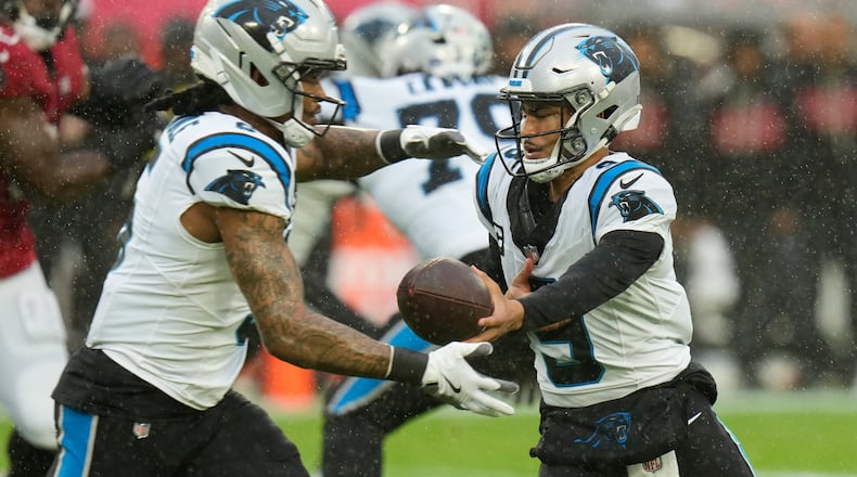 Carolina Panthers quarterback Bryce Young, right, hands off to running back Rico Dowdle (5) during the first half of an NFL football game Saturday, Jan. 3, 2026, in Tampa, Fla. (AP Photo/Chris O'Meara)