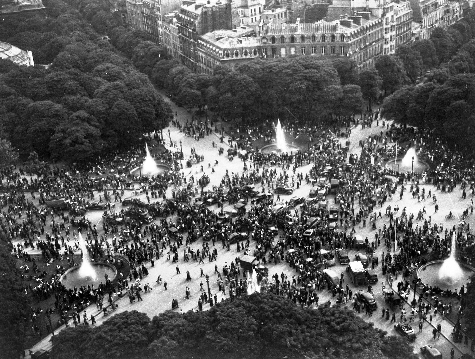 FILE - Happy crowds gather round the Rond-Point on the Champs-Elysees, Paris, France, on V-E Day, May 8, 1945, to celebrate the announcement of Germany's unconditional surrender. (AP Photo/Henry L. Griffin, File)