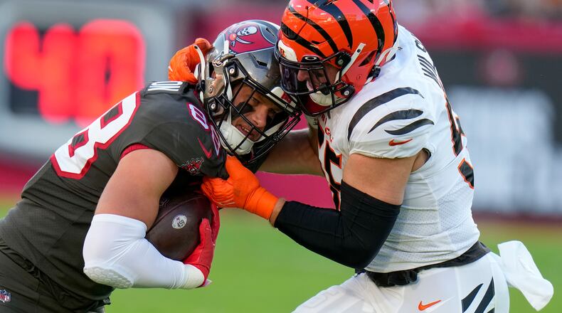 Tampa Bay Buccaneers tight end Cade Otton (88) is stopped by Cincinnati Bengals linebacker Logan Wilson (55) during the first half of an NFL football game, Sunday, Dec. 18, 2022, in Tampa, Fla. (AP Photo/Chris O'Meara)