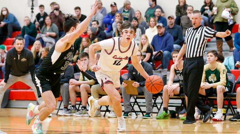 Cutline: Cedarville High School sophomore Tyler Cross is guarded by Catholic Central senior Ashton Young during their game on Friday night in Cedarville. The Indians upset the Irish 56-55. Michael Cooper/CONTRIBUTED
