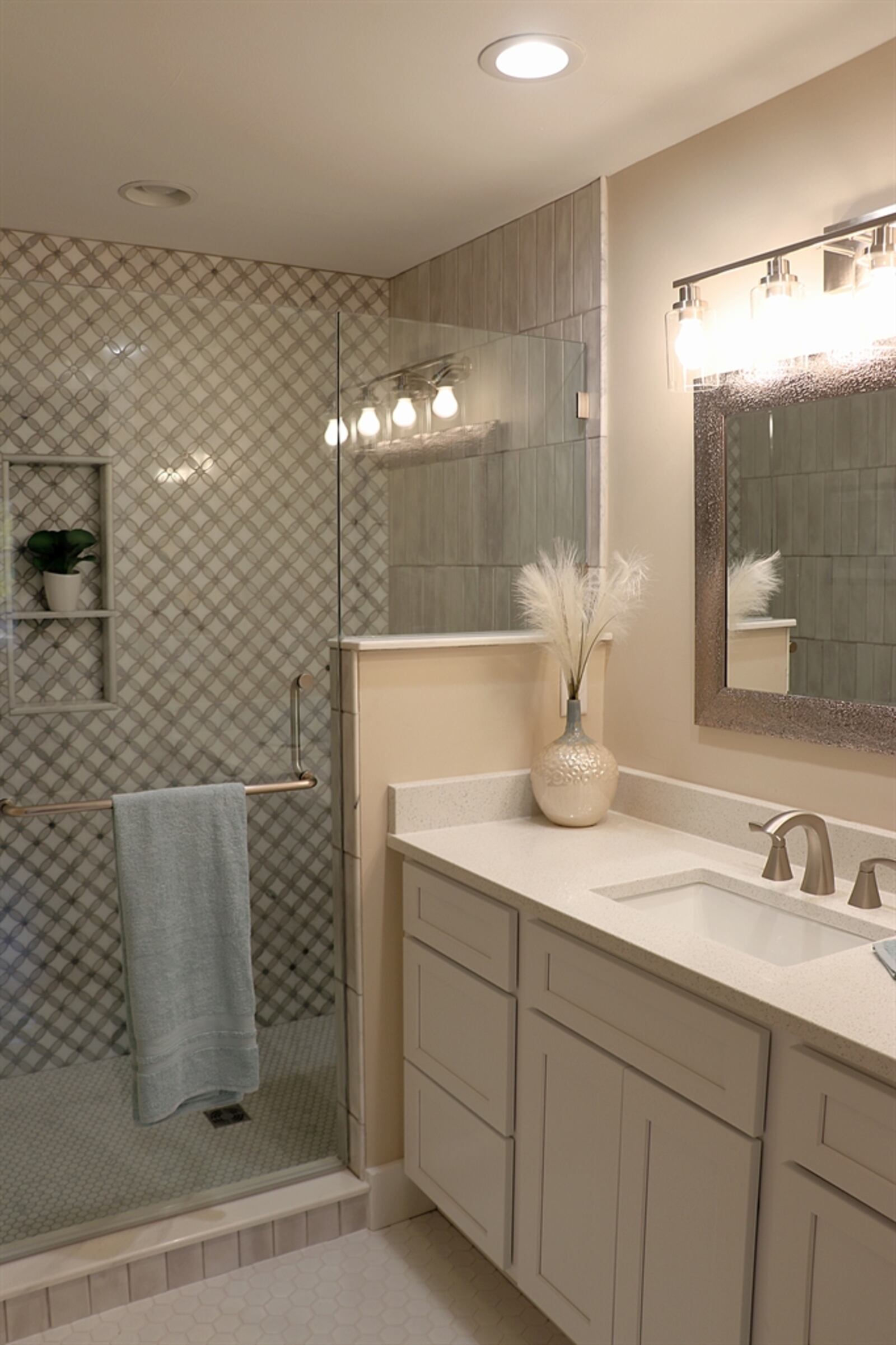 This bath features a glass-enclosed shower with built-in storage nooks and creative tile design. Contributed photo by Kathy Tyler