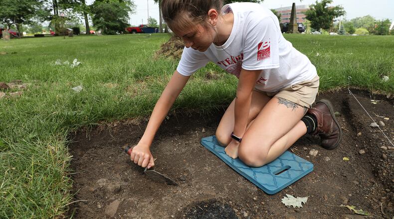 Wittenberg student Casey Juday, from New Carlisle, scrapes the ground in her archeological dig site Thursday, May 31, 2018 at the Columbia Street Cemetery. Bill Lackey/Staff
