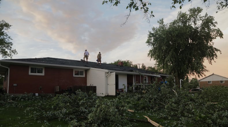 A homeowner repairs his roof along Delrey Road Wednesday evening, June 8, 2022, in German Twp. after it was damaged in the storms. An EF1 tornado touched down north of Springfield. BILL LACKEY/STAFF
