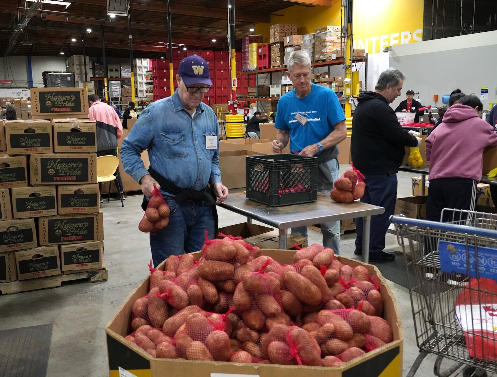 Volunteers pack produce at the Alameda County Community Food Bank in Alameda, Calif., on Friday, April 25, 2025. (AP Photo/Terry Chea)