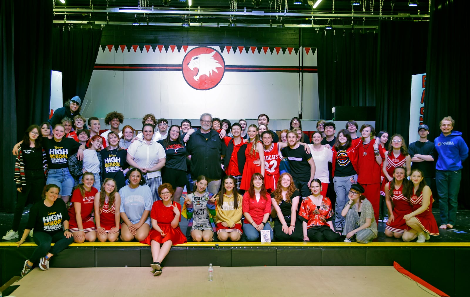 Director Bryan Szekacs and the cast of "High School Musical" Friday, April 19, 2024. This weekend's musical marks the 25th and last time Szekacs will direct the students in a performance. BILL LACKEY/STAFF