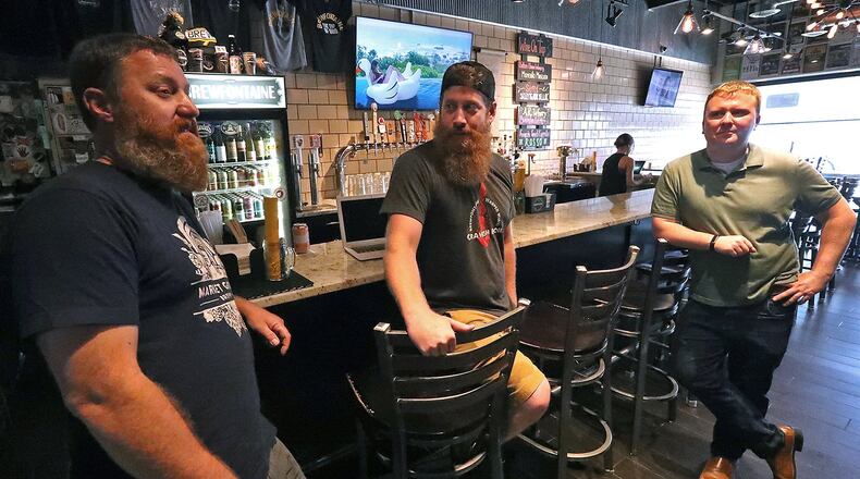 Brian Wall, left, and Jeremy Fitzpatrick, center, the owners of Brewfontaine, talk with Jason Duff about opening a business in downtown Bellefontaine. Bill Lackey/Staff