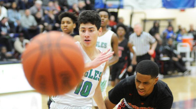 CJ senior Jack Nauseef (left) chases a loose ball during a recent Premier Health Flyin’ to the Hoop defeat of Akron Buchtel at Trent Arena. MARC PENDLETON / STAFF