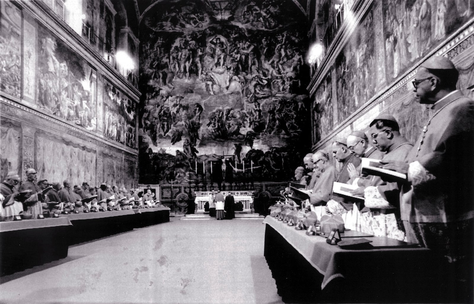 FILE - Cardinals stand in prayer inside the Sistine Chapel after they entered the conclave area for electing the successor of late John Paul I. In the background on the wall Michelangelo's famous fresco "The Last Judgement", in this Oct. 14, 1978 file photo. (AP Photo/Pool, File)