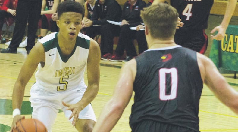 Catholic Central guard Trey Dunn (left) is guarded by Triad’s Briley Harlan on Tuesday night in Springfield. Dunn scored 12 points to help the Irish to a 64-56 victory. JEFF GILBERT / CONTRIBUTED