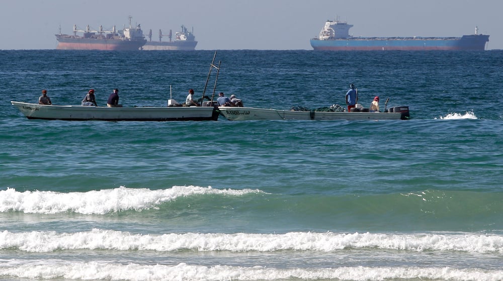 FILE - Fishermen work in front of oil tankers south of the Strait of Hormuz Jan. 19, 2012, offshore the town of Ras Al Khaimah in United Arab Emirates. (AP Photo/Kamran Jebreili, File)