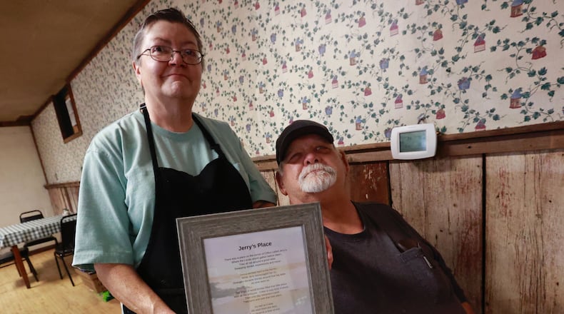 Jerry Huckleba and his wife, Donna, the owners of Jerry’s Country Corner in Clifton, hold a poem that one of their regular customers wrote for them Wednesday, Dec. 14, 2022, on their final day open. The Hucklebas are closing their restaurant, which has become a landmark, after 39 years. BILL LACKEY/STAFF