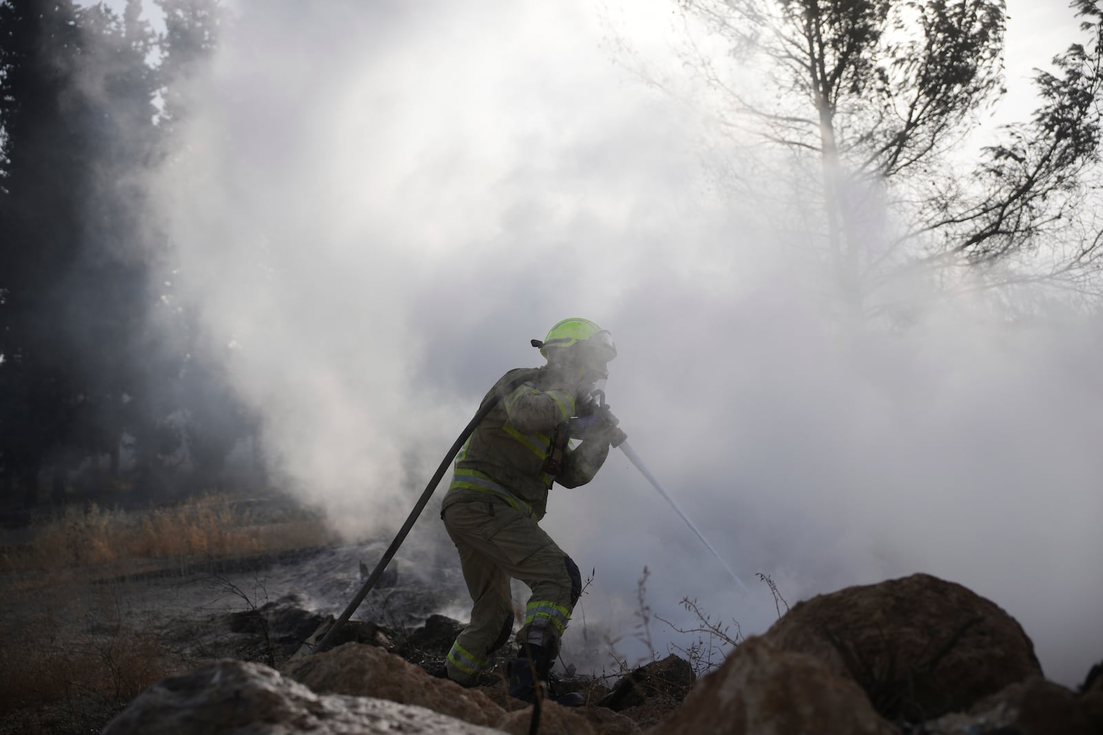 An Israeli firefighter battles a wild fire near Latrun, Israel, outside of Jerusalem Thursday, May 1, 2025. (AP Photo/Ohad Zwigenberg)