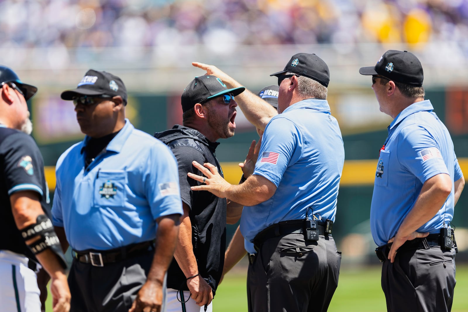 Coastal Carolina head coach Kevin Schnall, center left, screams at the umpires after being ejected in the first inning against LSU in Game 2 of the NCAA College World Series baseball finals in Omaha, Neb., Sunday, June 22, 2025. (AP Photo/Rebecca S. Gratz)