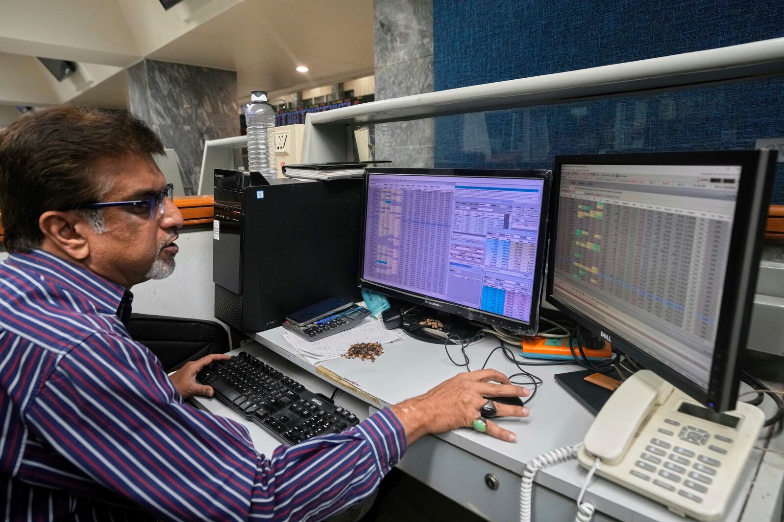 A stock broker checks indexes and benchmark 100 index at the Pakistan Stock Exchange (PSE), in Karachi, Pakistan, Monday, April 7, 2025. (AP Photo/Fareed Khan)