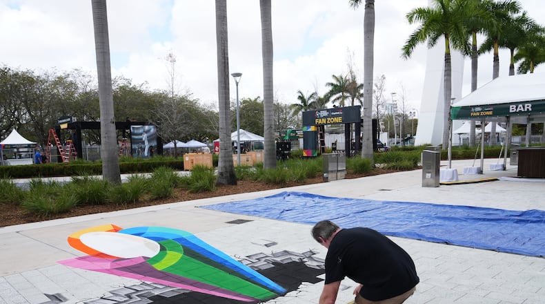 Artist Mike Macaulay paints a World Baseball Classic logo outside of loanDepot Park in advance of the World Baseball Classic, Thursday, March 5, 2026, in Miami. (AP Photo/Lynne Sladky)