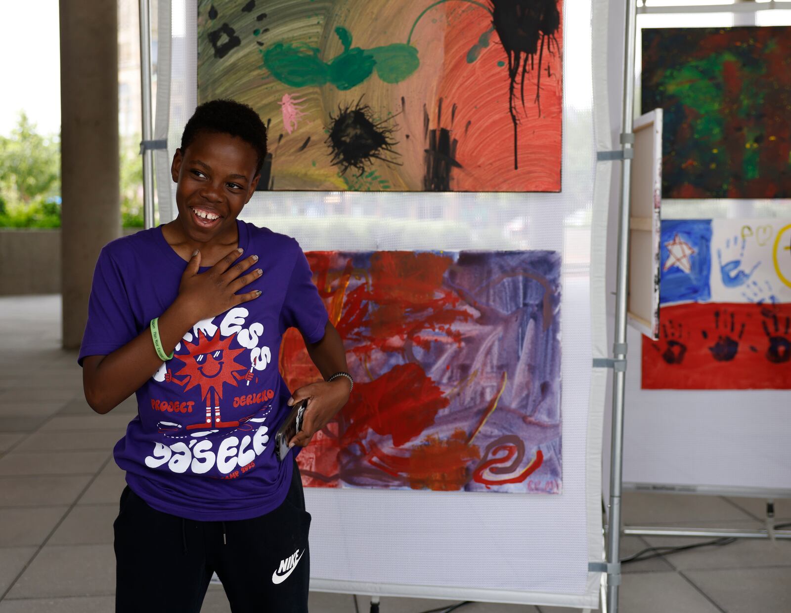 A young kid shows off his artwork during Project Jericho Summer Arts Camp on Friday, June 13, 2025, at Springfield City Plaza. JOSEPH COOKE/STAFF
