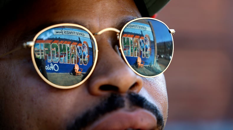 The "Greetings from Springfield" mural is reflected in William Green's sunglasses as he talks about the city and its Haitian population Wednesday, Sept. 11, 2024. BILL LACKEY/STAFF